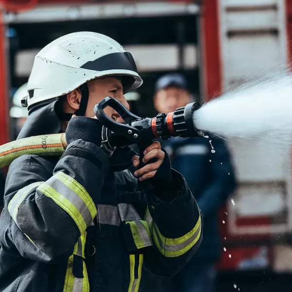 Fireman with water hose over his shoulder